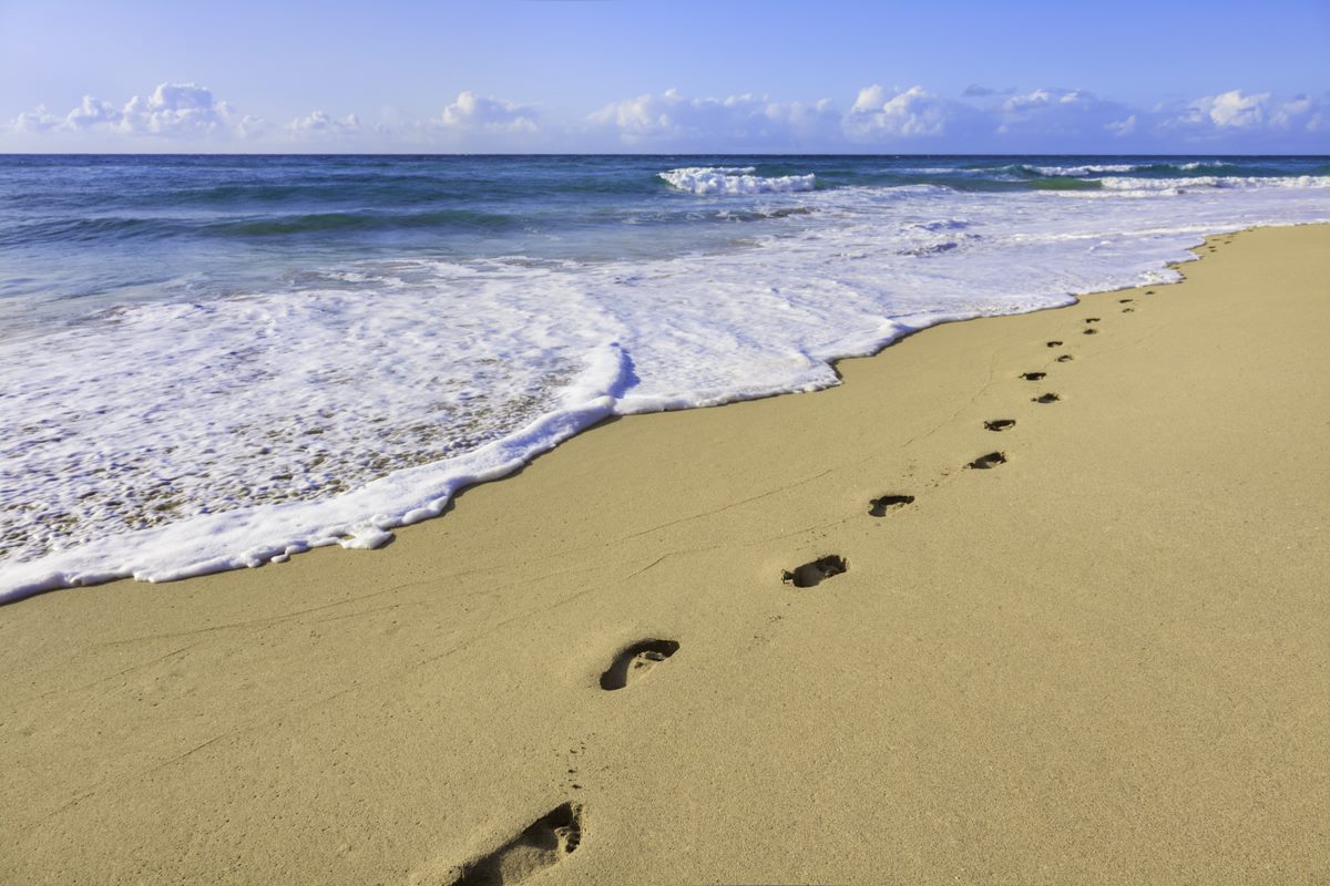 walking with purpose leaves footprints on a beach.